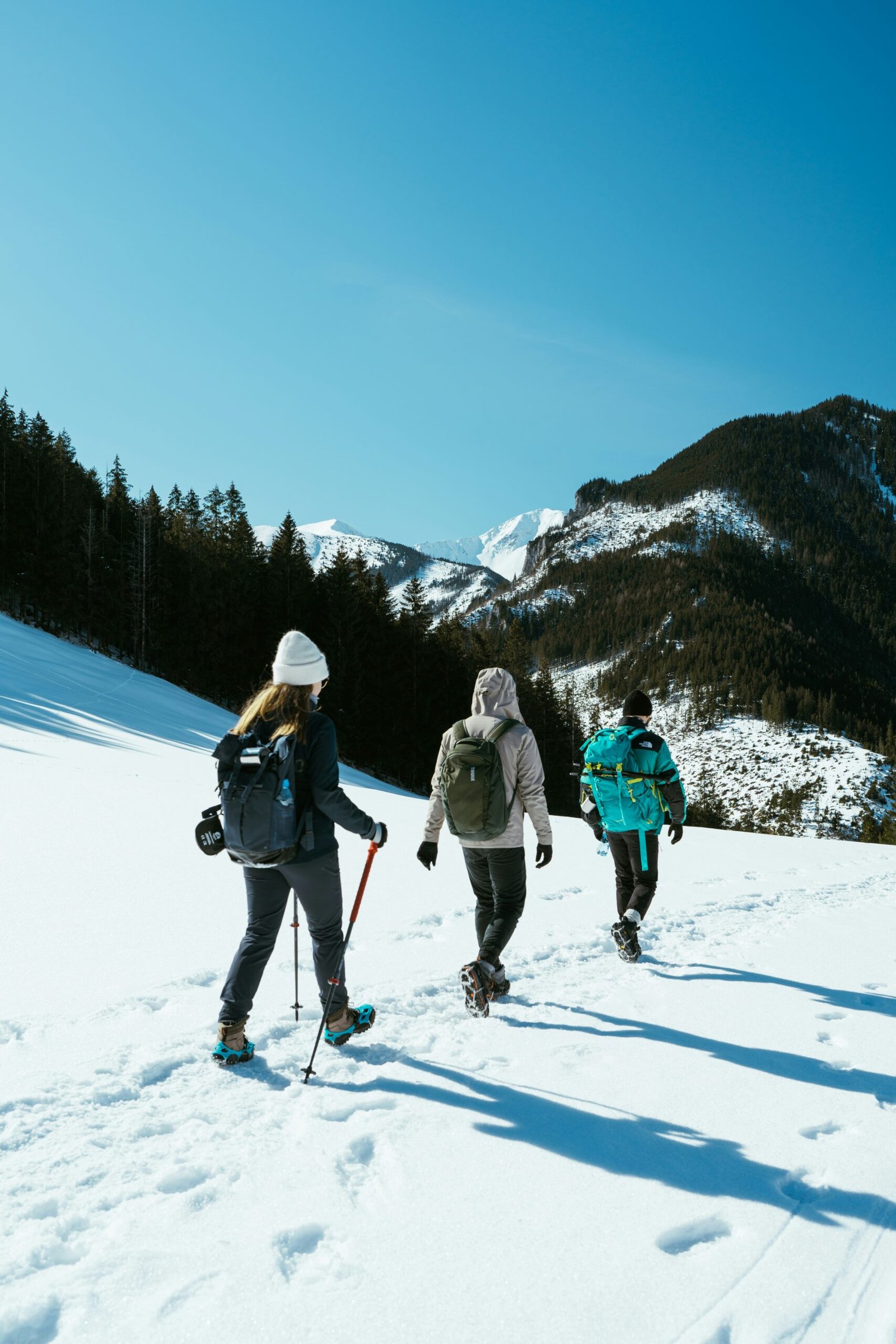 a group of people walking across a snow covered slope