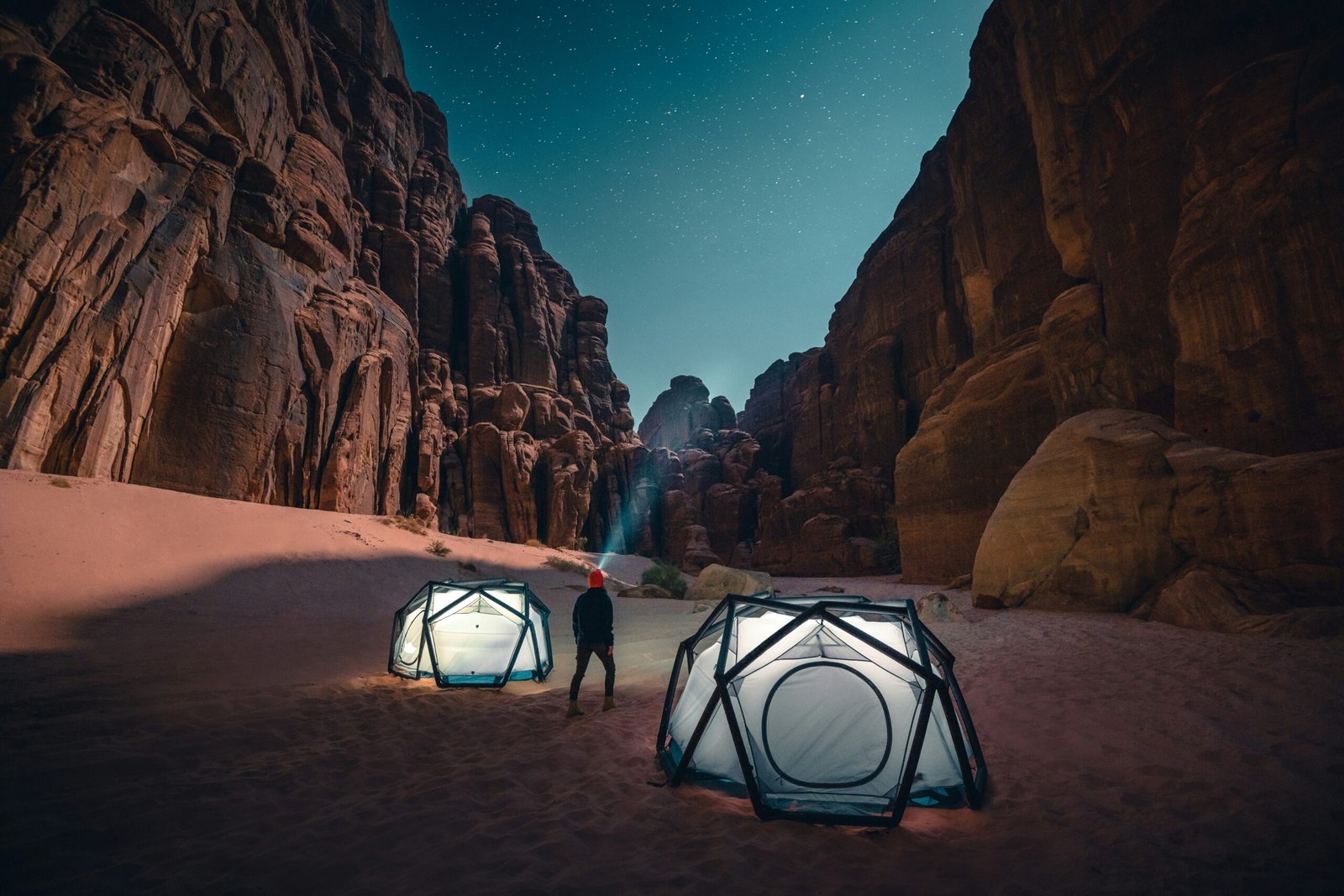 a man standing next to a tent in the desert